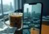 Best AI Photo Enhancer Apps: Instantly Upgrade Your Pics Like a Pro A smartphone on a rickety wooden desk displays a split-screen of a blurry, rain-smeared Seattle skyline selfie transforming into a sharp, vibrant shot. A half-spilled iced coffee mug with a wonky shadow and a crumpled napkin with doodled pixel hearts sit nearby. A tiny cartoon robot arm emerges from the phone's port, giving a thumbs-up, blending muted teal grays with electric orange highlights in a wryly humorous, slightly blurred photorealistic style.