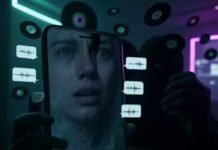 Scarily Real AI Voice Changer Apps: Sound Like Anyone Instantly! A shadowy figure holds a glowing smartphone in a dimly lit room, its screen displaying a distorted human face morphing into a celebrity's, surrounded by eerie neon-green speech bubbles with audio waveforms. Floating vinyl records turn into digital pixels, blending cyberpunk neon purples and deep blacks with a wryly humorous yet unnerving tone.