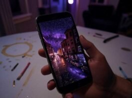 Double Exposure Apps: Unleash Your Inner Surrealist and Create Stunning Masterpieces A shaky hand holds a phone displaying a double exposure of a neon Boston street merging with a galaxy, set against a purple-amber-crimson late-night vibe. A coffee stain and glowing paintbrushes litter the messy Somerville apartment table.