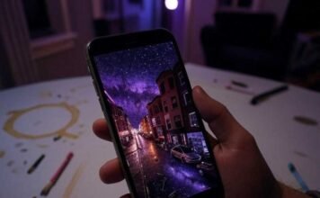 Double Exposure Apps: Unleash Your Inner Surrealist and Create Stunning Masterpieces A shaky hand holds a phone displaying a double exposure of a neon Boston street merging with a galaxy, set against a purple-amber-crimson late-night vibe. A coffee stain and glowing paintbrushes litter the messy Somerville apartment table.